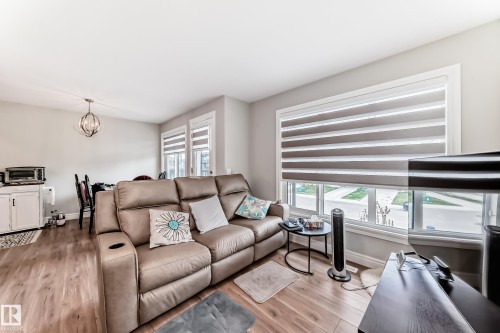 This inviting living space features light wood flooring and neutral wall tones, creating a bright atmosphere - 7822 Koruluk Link Link, Edmonton, AB - Indoor Photo Showing Living Room