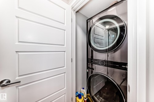 Laundry area featuring a stacked washer and dryer unit - 7822 Koruluk Link Link, Edmonton, AB - Indoor Photo Showing Laundry Room