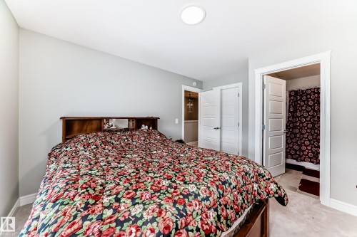 This room features carpeted flooring, light grey walls, and a recessed ceiling light - 7822 Koruluk Link Link, Edmonton, AB - Indoor Photo Showing Bedroom