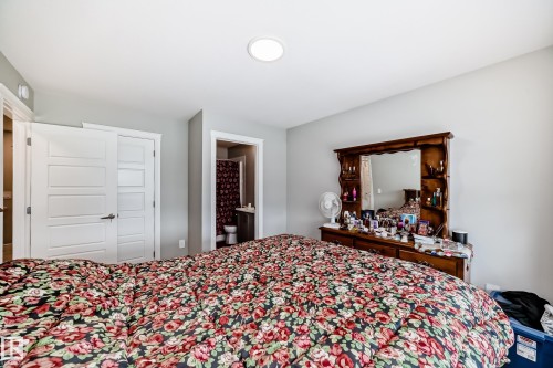 This bedroom features light gray walls and white trim, with a ceiling light fixture - 7822 Koruluk Link Link, Edmonton, AB - Indoor Photo Showing Bedroom