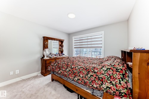 This room features a window with blinds, light gray walls, and light-colored carpet flooring - 7822 Koruluk Link Link, Edmonton, AB - Indoor Photo Showing Bedroom