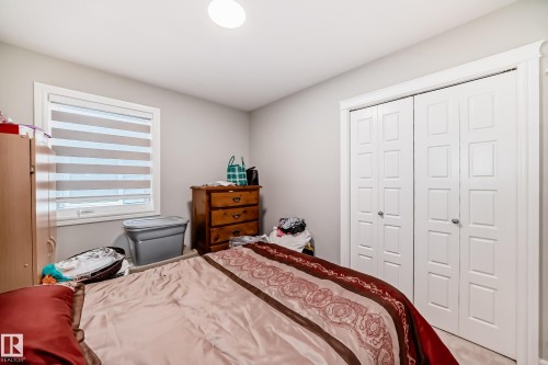 This room features a window with blinds, a ceiling light fixture, and white bi-fold closet doors - 7822 Koruluk Link Link, Edmonton, AB - Indoor Photo Showing Bedroom