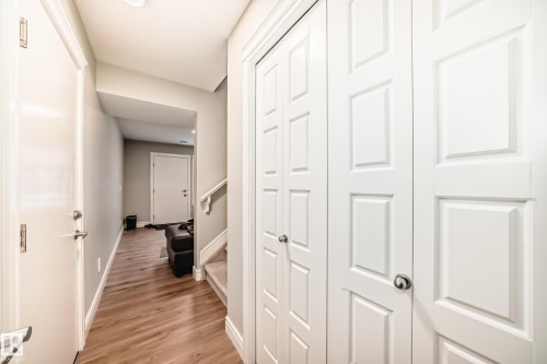 The property features a hallway with light wood flooring, white doors, and light gray walls - 7822 Koruluk Link Link, Edmonton, AB - Indoor Photo Showing Other Room