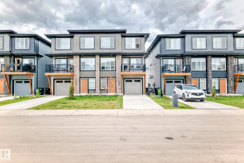The property features a contemporary exterior with a combination of grey siding, stone accents, and light-colored wood detailing - 7822 Koruluk Link Link, Edmonton, AB - Outdoor With Balcony With Facade