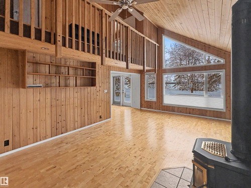 The property features a spacious room with wood paneling, a high vaulted ceiling, and light-colored wood flooring - #4 Kingbird Road, Rural Bonnyville M.D., AB 