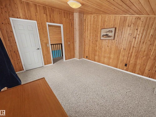 This room features wood-paneled walls and ceiling, providing a distinct aesthetic - #4 Kingbird Road, Rural Bonnyville M.D., AB 