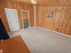 This room features wood-paneled walls and ceiling, providing a distinct aesthetic - 