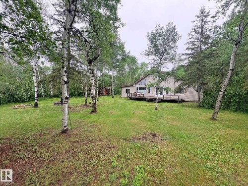 Spacious backyard with mature trees and a large wooden deck - #4 Kingbird Road, Rural Bonnyville M.D., AB 