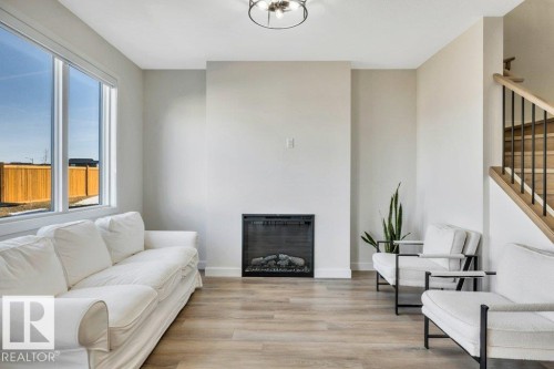 Bright living area with large windows, a fireplace, and light-toned flooring - 13007 213 Street, Edmonton, AB - Indoor Photo Showing Living Room