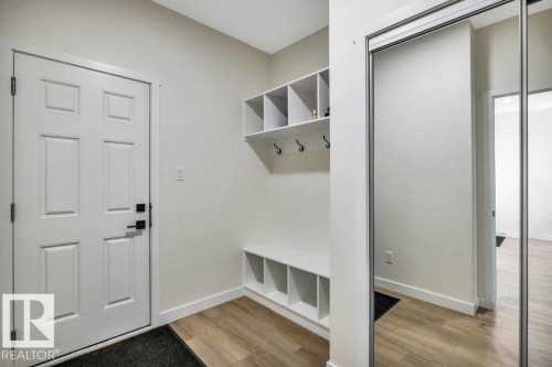 Entryway featuring paneled doors, light wood flooring, and built-in storage with hooks - 13007 213 Street, Edmonton, AB - Indoor Photo Showing Other Room