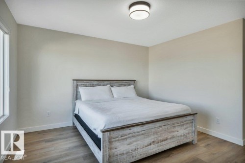 This room features light-colored walls, light wood-style flooring, and a window providing natural light - 13007 213 Street, Edmonton, AB - Indoor Photo Showing Bedroom