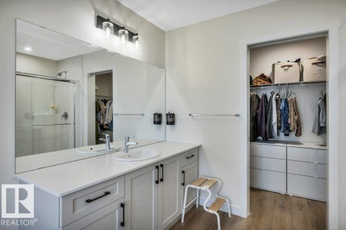 Bathroom featuring a large vanity with white countertops, an undermount sink, and a spacious mirror - 13007 213 Street, Edmonton, AB - Indoor Photo Showing Other Room