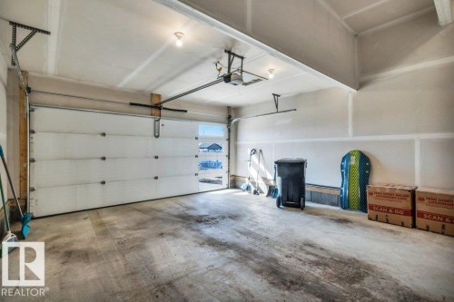 The property features a garage with a white sectional overhead door, complete with windows for natural light - 13007 213 Street, Edmonton, AB - Indoor Photo Showing Garage