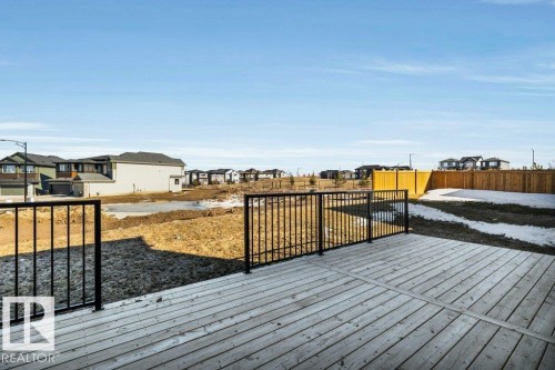 The property features a spacious deck with light-toned decking and black railings, offering views of the surrounding area - 13007 213 Street, Edmonton, AB - Outdoor