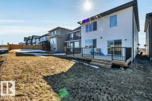 The property features a rear deck with black railings and two sliding glass doors, providing outdoor access - 13007 213 Street, Edmonton, AB - Outdoor