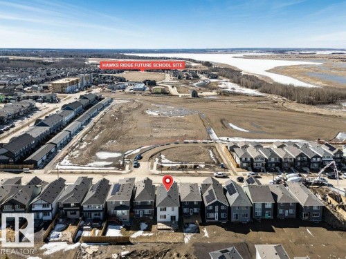 Aerial view of a residential area featuring detached homes and townhomes, with a body of water visible in the background - 13007 213 Street, Edmonton, AB - Outdoor With View