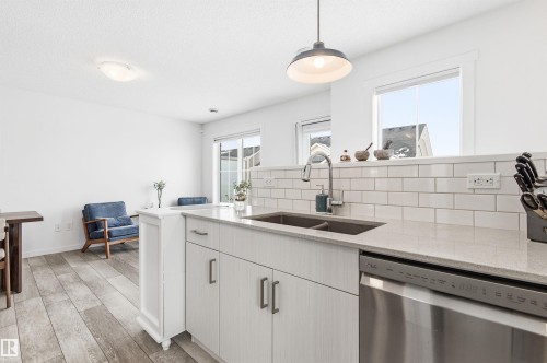 The kitchen features a double basin sink, light-colored countertops, and a subway tile backsplash - 58 1110 Daniels Link Link, Edmonton, AB - Indoor Photo Showing Kitchen With Double Sink