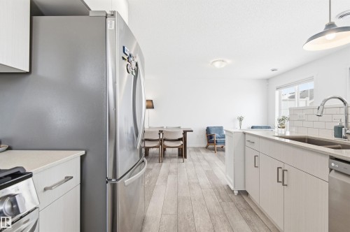 The property features a kitchen with light-toned cabinetry, stainless steel appliances, and a light countertop - 58 1110 Daniels Link Link, Edmonton, AB - Indoor Photo Showing Kitchen With Double Sink