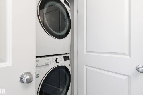 Dedicated laundry space featuring a stacked washer and dryer unit - 58 1110 Daniels Link Link, Edmonton, AB - Indoor Photo Showing Laundry Room