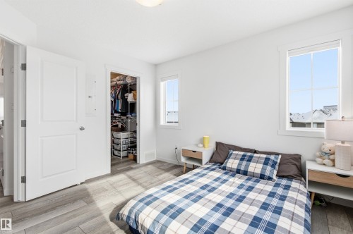 The property features light wood flooring, white walls, and two windows allowing for natural light - 58 1110 Daniels Link Link, Edmonton, AB - Indoor Photo Showing Bedroom
