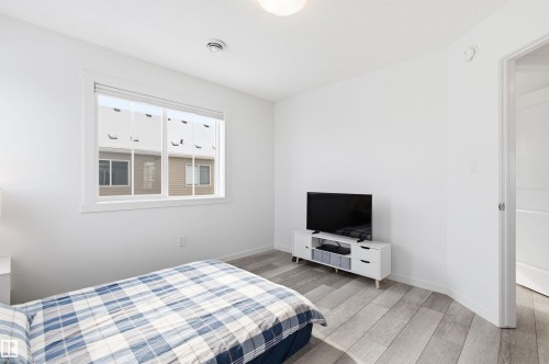 This room features light-colored flooring, a window providing natural light, and clean white walls - 58 1110 Daniels Link Link, Edmonton, AB - Indoor Photo Showing Bedroom