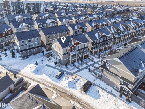 Aerial view showcasing the property's location within a residential area featuring rows of townhomes and a multi-story building - 58 1110 Daniels Link Link, Edmonton, AB - Outdoor