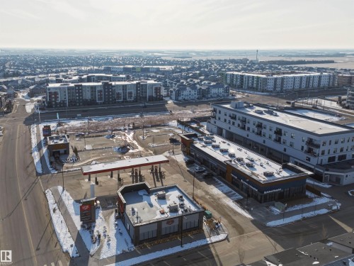 Expansive aerial view of the property's surroundings, showcasing nearby multi-story residential buildings, commercial structures, and roadways - 58 1110 Daniels Link Link, Edmonton, AB - Outdoor With View