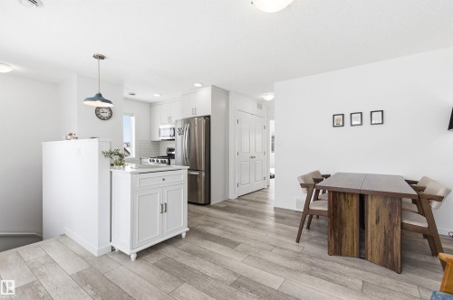 The property features a kitchen and dining area with light-colored flooring, white walls, and recessed lighting - 58 1110 Daniels Link Link, Edmonton, AB - Indoor