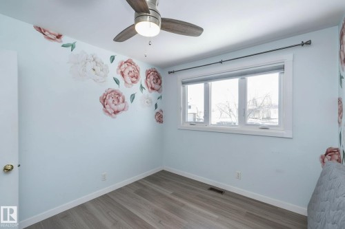 This room features a ceiling fan, a window with a roller blind, and light-colored flooring - 12 Mill Drive, St. Albert, AB - Indoor Photo Showing Other Room