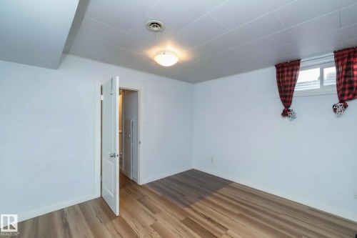 This room features light-toned wood flooring, white walls, and a ceiling light fixture - 12 Mill Drive, St. Albert, AB - Indoor Photo Showing Other Room