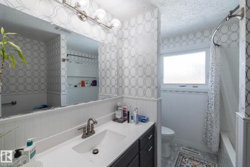 This bathroom features a vanity with a white countertop and a silver-toned faucet - 12 Mill Drive, St. Albert, AB - Indoor Photo Showing Bathroom