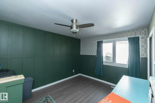 This room features dark paneled walls, a window with curtains, and a ceiling fan - 12 Mill Drive, St. Albert, AB - Indoor Photo Showing Other Room