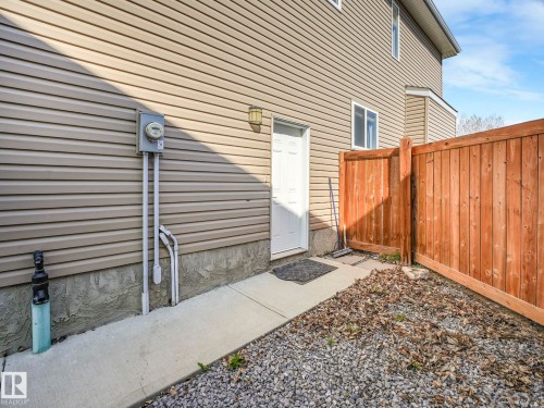 The property features light-colored horizontal siding and a concrete walkway - 3910 49 Avenue, Beaumont, AB - Outdoor With Exterior