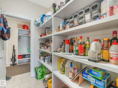 This property features a spacious pantry with extensive built-in shelving, providing ample storage - 3910 49 Avenue, Beaumont, AB - Indoor With Storage