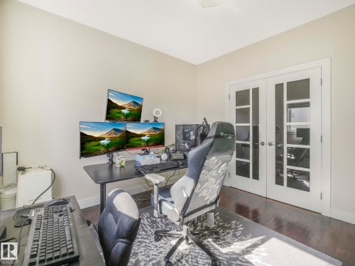 This room features hardwood floors and a set of white French doors with glass panes - 3910 49 Avenue, Beaumont, AB - Indoor