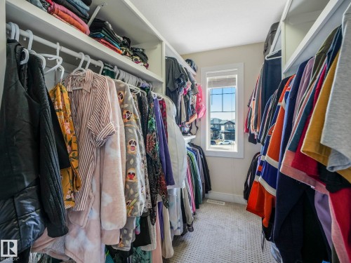 The property features a walk-in closet with built-in shelving, hanging rods, and a window providing natural light - 3910 49 Avenue, Beaumont, AB - Indoor With Storage