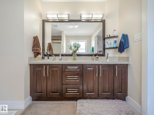 Bathroom with a spacious double vanity featuring dark wood cabinetry and a light-colored countertop - 3910 49 Avenue, Beaumont, AB - Indoor Photo Showing Bathroom