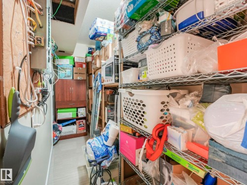 The property includes a dedicated storage space with metal shelving and a wooden cabinet - 3910 49 Avenue, Beaumont, AB - Indoor