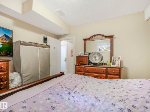 This room features light-colored walls and a textured ceiling - 3910 49 Avenue, Beaumont, AB - Indoor Photo Showing Bedroom