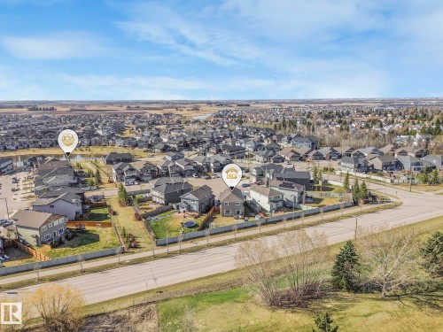 Aerial view showcasing the residential neighbourhood with numerous properties, green spaces, and a visible road - 3910 49 Avenue, Beaumont, AB - Outdoor With View
