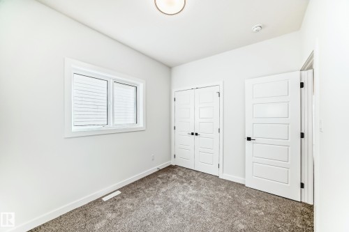 This bright interior space features white walls, clean white trim, and a window providing natural light - 341 Roberts Wynd, Leduc, AB - Indoor Photo Showing Other Room