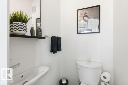 Bathroom featuring a wall-mounted sink with a modern faucet, a wall-mounted towel bar, and a toilet - 