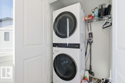 Dedicated laundry area featuring a stacked washer and dryer unit - 