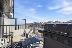 Enjoy outdoor living on the balcony, featuring black railings, privacy screens, and a patterned outdoor rug - 