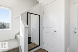 This property features a staircase with carpeted steps and a white railing - 