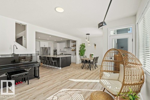 This open-concept living space features light-toned flooring, recessed lighting, and large windows with blinds - 21003 131 Avenue, Edmonton, AB - Indoor