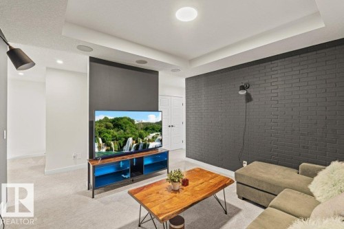 Living space featuring light-colored carpeting, a dark brick accent wall, and recessed ceiling lighting - 21003 131 Avenue, Edmonton, AB - Indoor Photo Showing Other Room