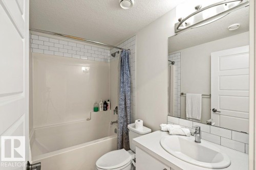 Bathroom featuring a vanity with an undermount sink, a mirror, and a bathtub with white subway tile surround - 21003 131 Avenue, Edmonton, AB - Indoor Photo Showing Bathroom