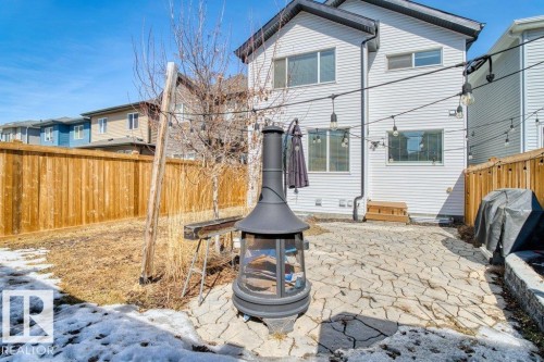 The property features a fenced yard with a stone patio area and a chiminea - 21003 131 Avenue, Edmonton, AB - Outdoor