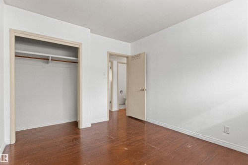 This room features rich wood flooring and a convenient open closet with a hanging rod - 8608 156 Street, Edmonton, AB - Indoor Photo Showing Other Room